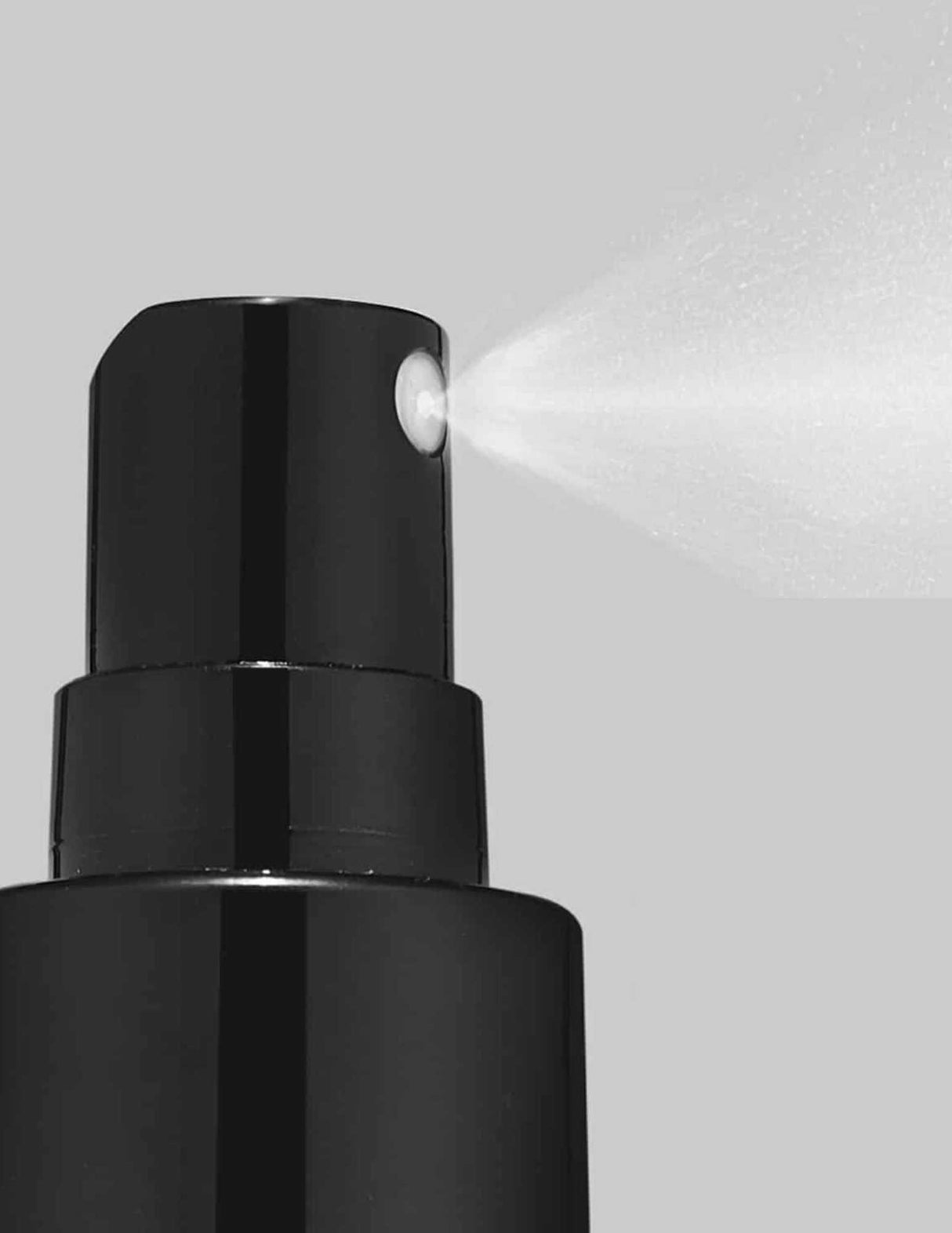 Close-up of Redken Quick Blowout spray bottle dispensing mist for faster blow-drying and heat protection on all hair types.