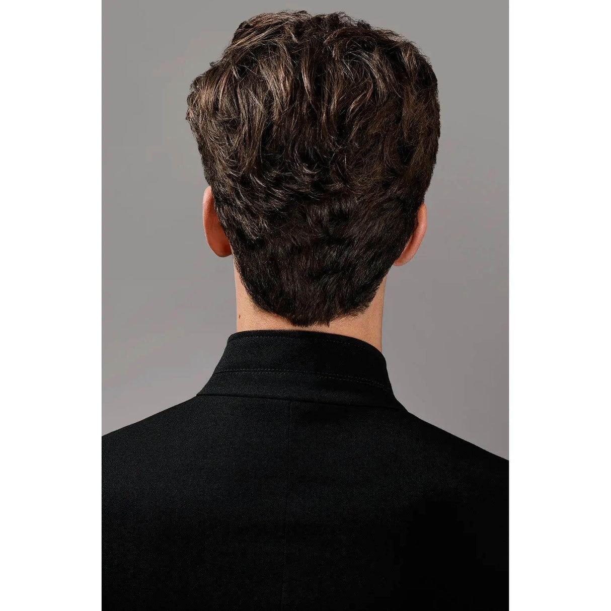 Back view of a man with styled, textured hair showing the effect of soft molding paste.