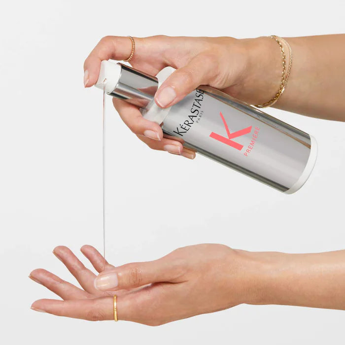 Applying Concentré Ultra-Réparateur, a pre-shampoo treatment for repairing calcium-damaged hair, from a silver pump bottle.