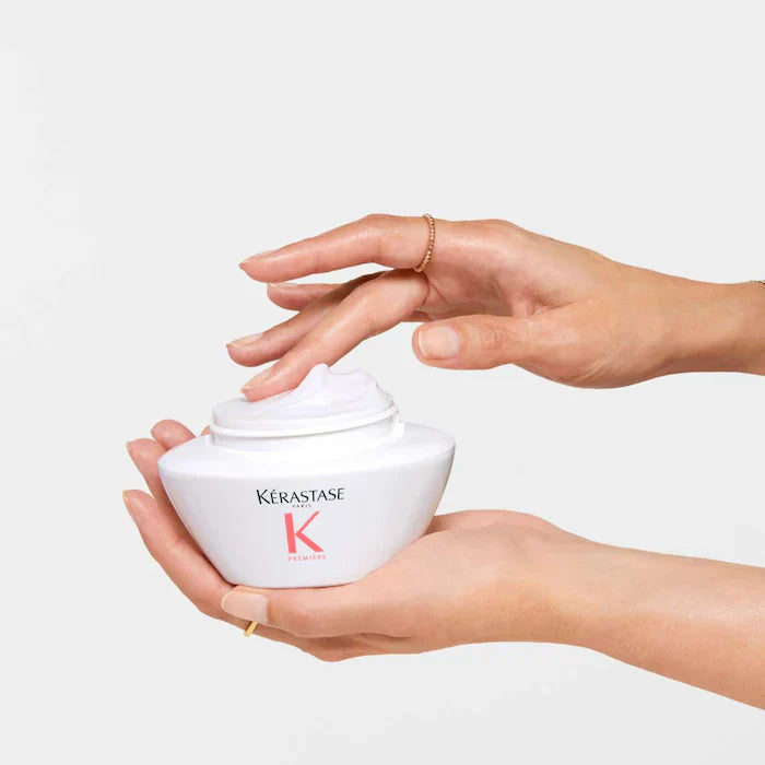 Hands holding Kerastase Masque Filler Réparateur for damaged hair, showcasing its creamy texture ideal for hair restoration.