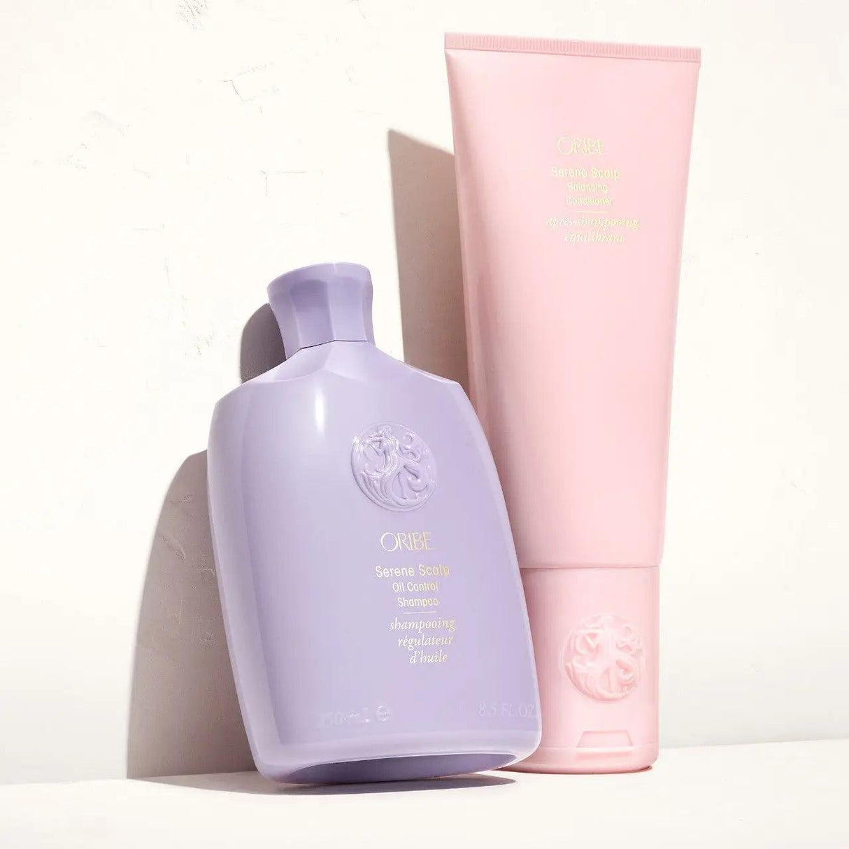 Oribe Serene Scalp Oil Control Shampoo and Conditioner bottles against a neutral background.