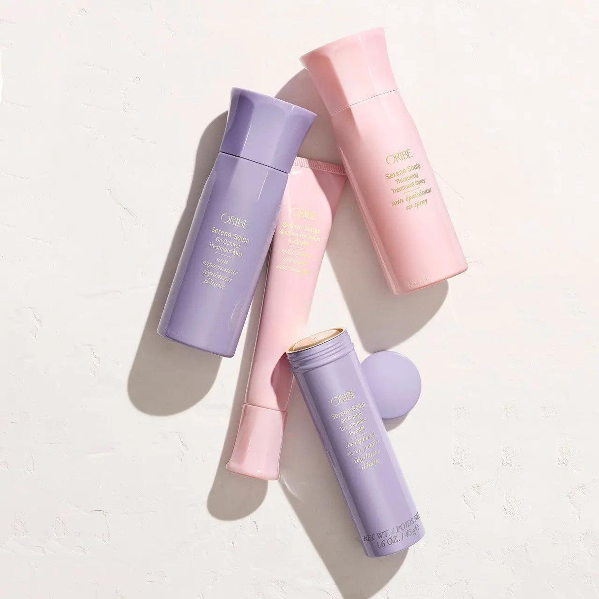 Assorted Oribe hair care products, including Serene Scalp Oil Control Treatment Mist, displayed on a light surface.