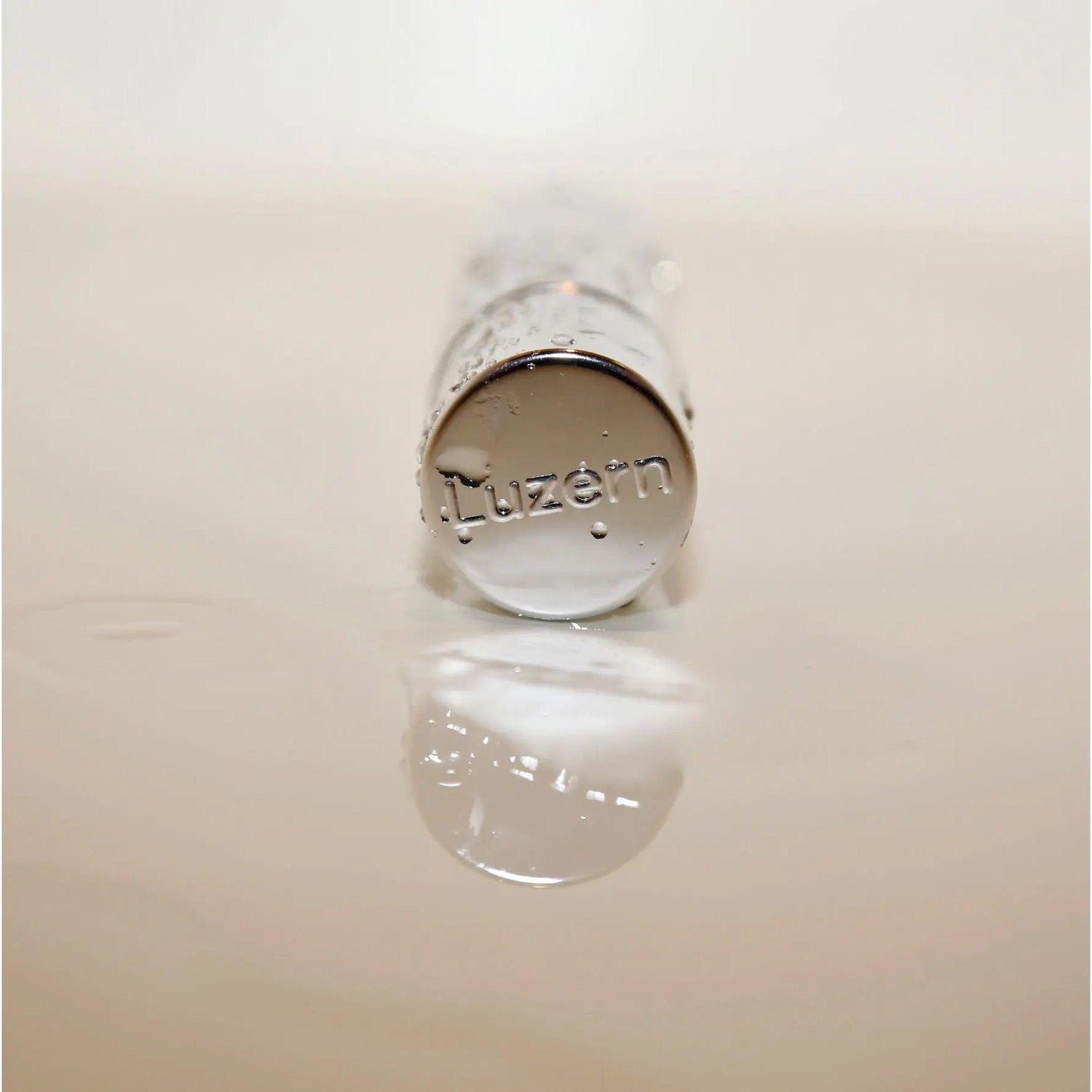 Luzern Serum Absolut Rehydrate bottle lying on side with reflection, emphasizing hydration and skincare benefits.