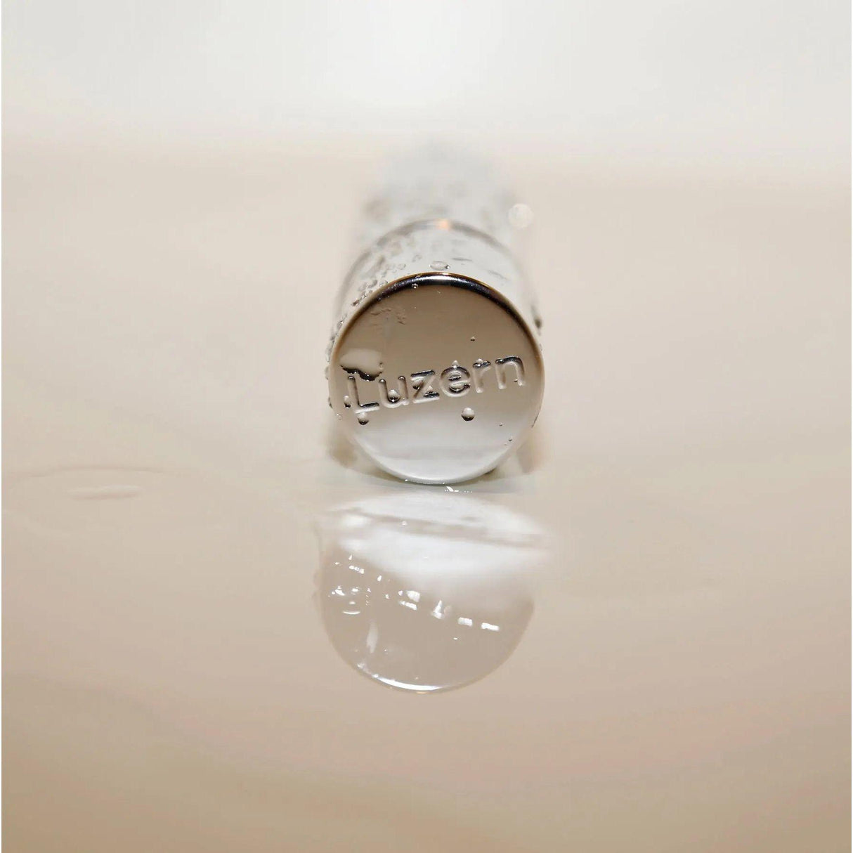 Close-up of Serum Absolut We3 bottle cap with 'Luzern' engraved, showcasing anti-aging serum for smoother, youthful skin.