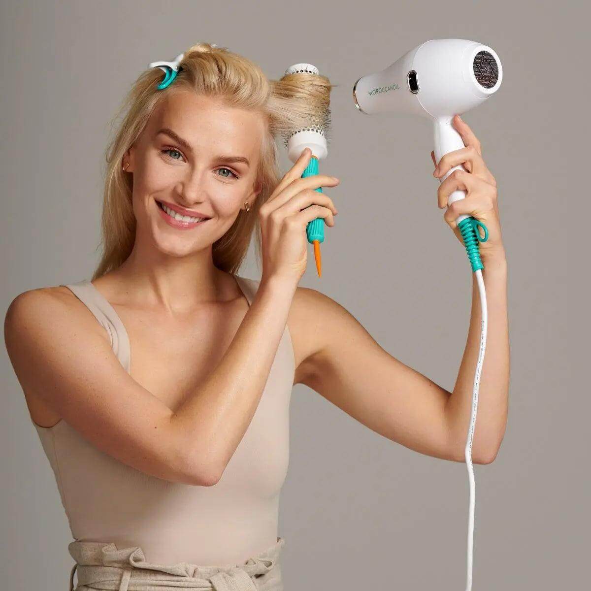 Woman using Smart Styling Infrared Hair Dryer for easy and precise styling with ceramic honeycomb heating and lightweight design.