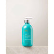 Bottle of Moroccanoil Smoothing Lotion, an all-in-one blow-dry hair lotion for silky, manageable hair with argan oil and Vitamin E.