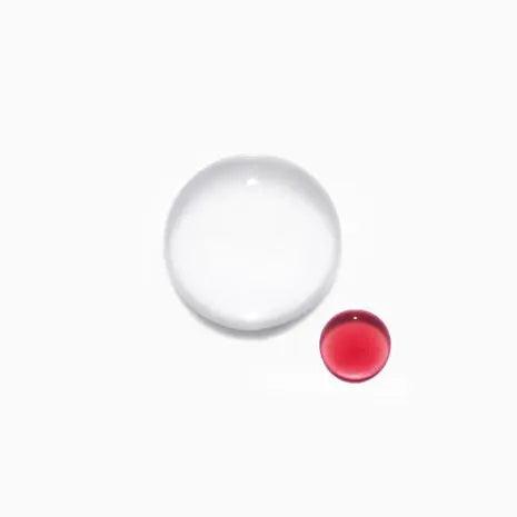 Close-up of two liquid drops, one clear and one red, showcasing the texture and diversity of hair care formulations.