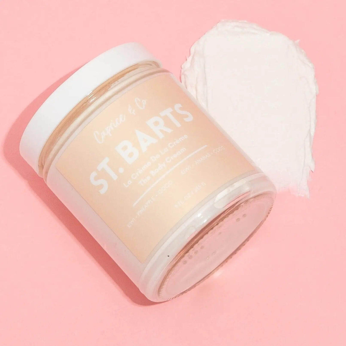 St-Barts body cream jar open on pink background, kiwi, pineapple, coconut scent, 9 fl oz, moisturizing, lightweight, in recyclable glass.