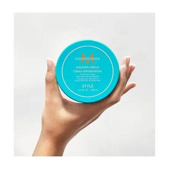 Hand holding Style Molding Cream, fiber-rich texturizing cream with argan and olive oils for natural texture and definition.