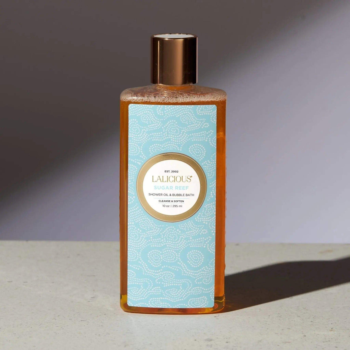 Sugar Reef Shower Oil & Bubble Bath bottle on a neutral background.
