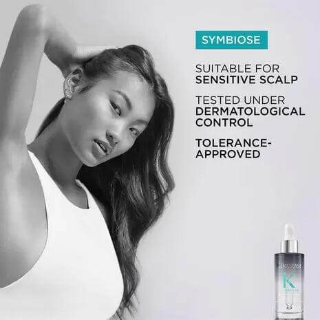 Woman with long hair posing with Kerastase Symbiose Sérum Nuit Intensif, suitable for sensitive scalp and dermatological control tested.