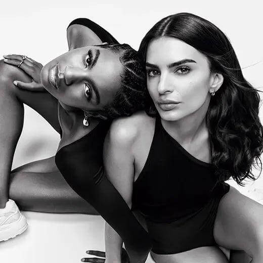 Two women posing in black and white fashion photography.
