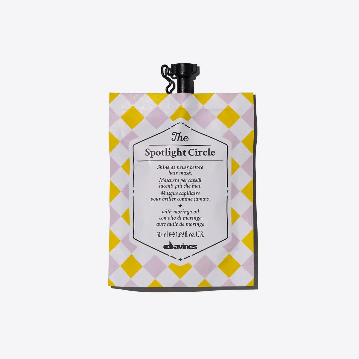 The Spotlight Circle extra shine-enhancing hair mask by Davines in a checkerboard patterned pouch, ideal for dull hair.