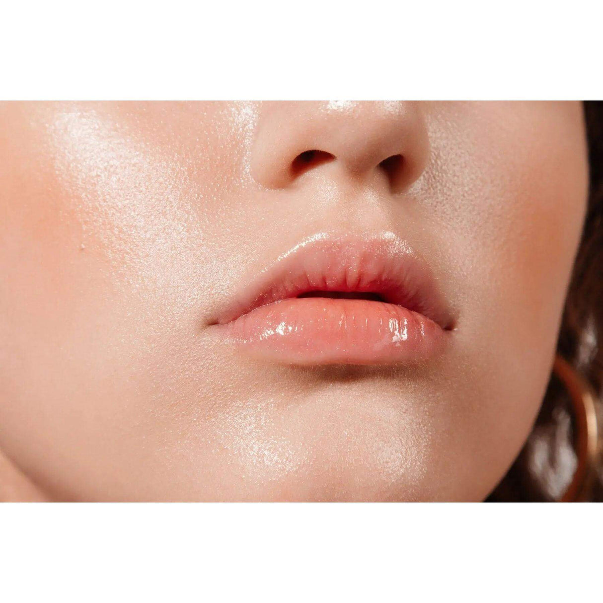 Close-up of glossy lips and smooth, hydrated skin highlighting the effects of The Sublime Oil for a youthful, radiant complexion.