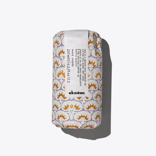 Davines product with stylish packaging, enhances curls, provides medium hold, and eliminates frizz for structured wet looks.