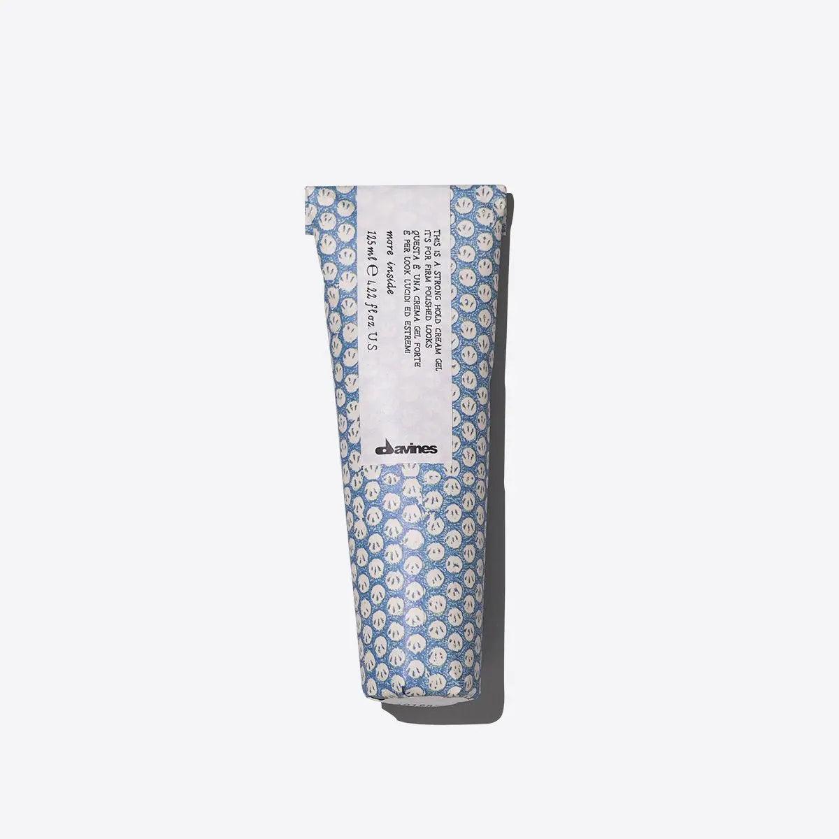 Tube of strong hold cream gel for defining short hairstyles with a wet look and frizz control, in patterned blue packaging.