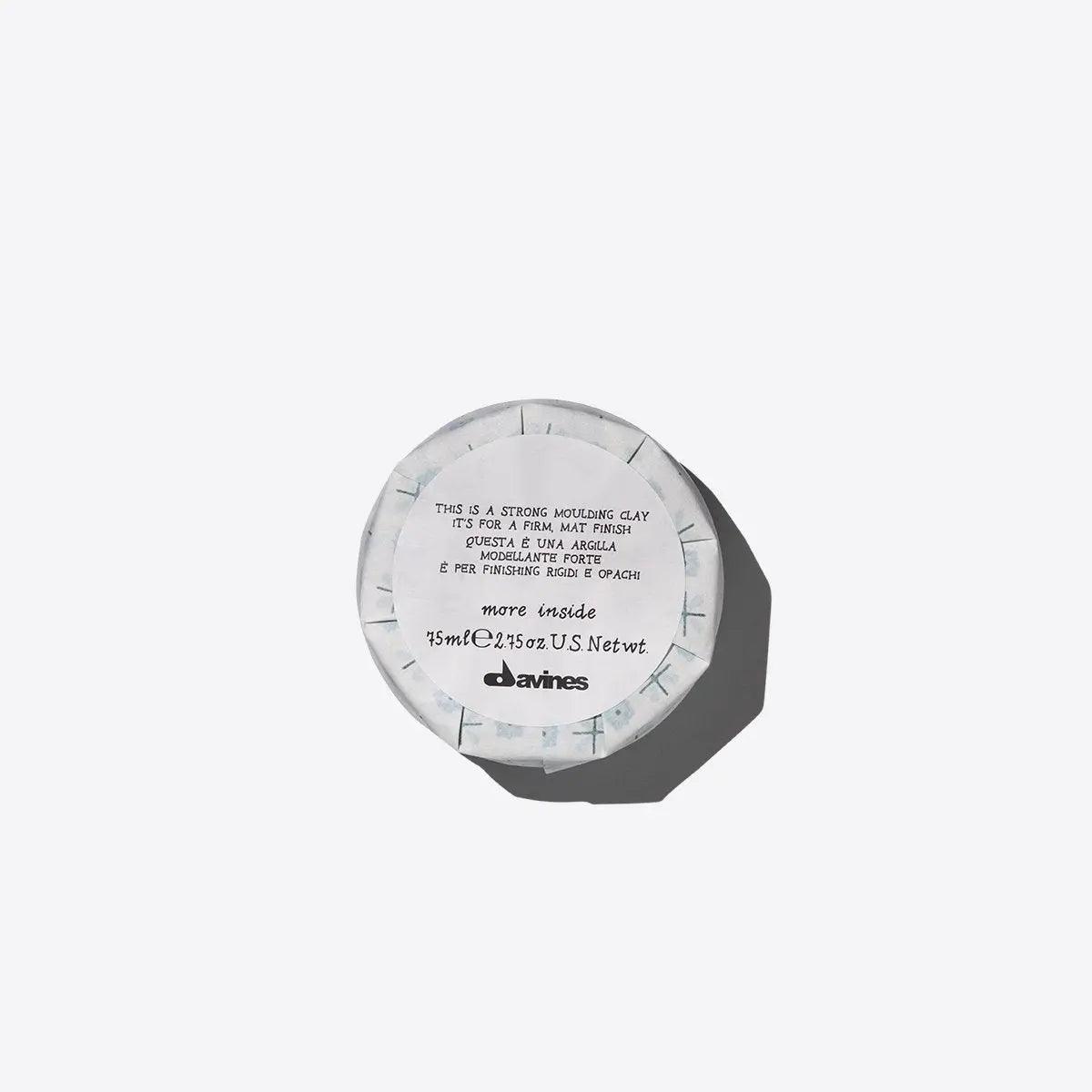Top view of "This Is A Strong Moulding Clay" jar for matte styles with firm hold, offering non-sticky hairstyling versatility.