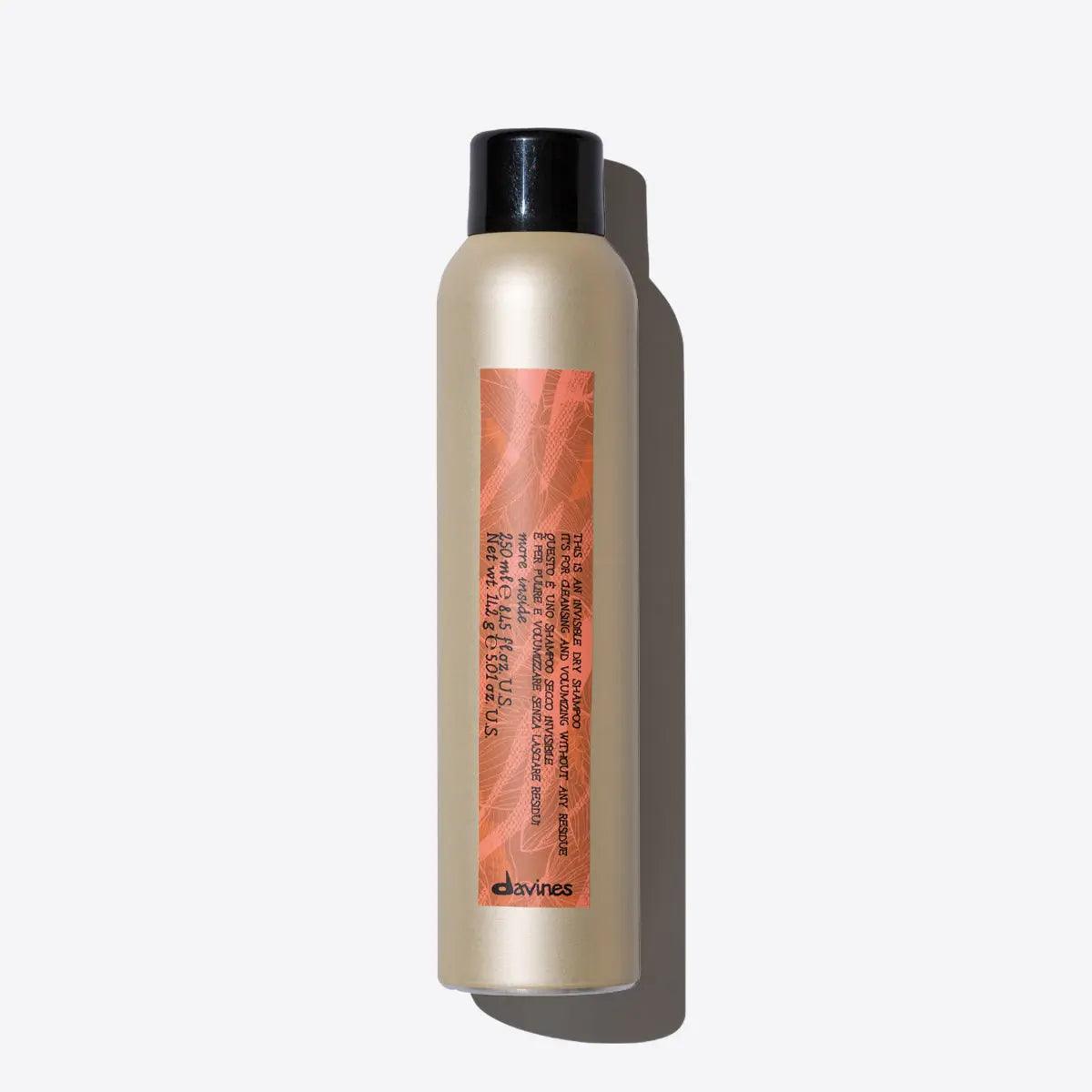 Bottle of invisible dry shampoo for volumizing and refreshing hair without residue, extending blow-dry longevity.