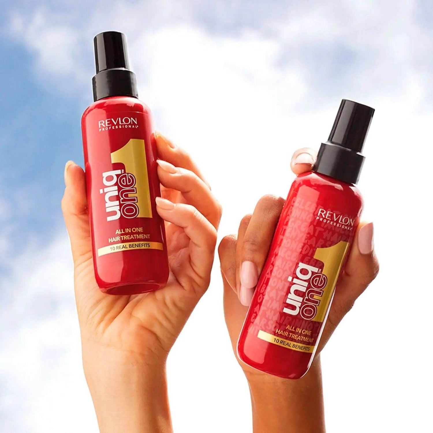 Two bottles of Uniqone™ Hair Treatment held against a blue sky, showcasing its multi-benefit leave-in formula for all hair types.