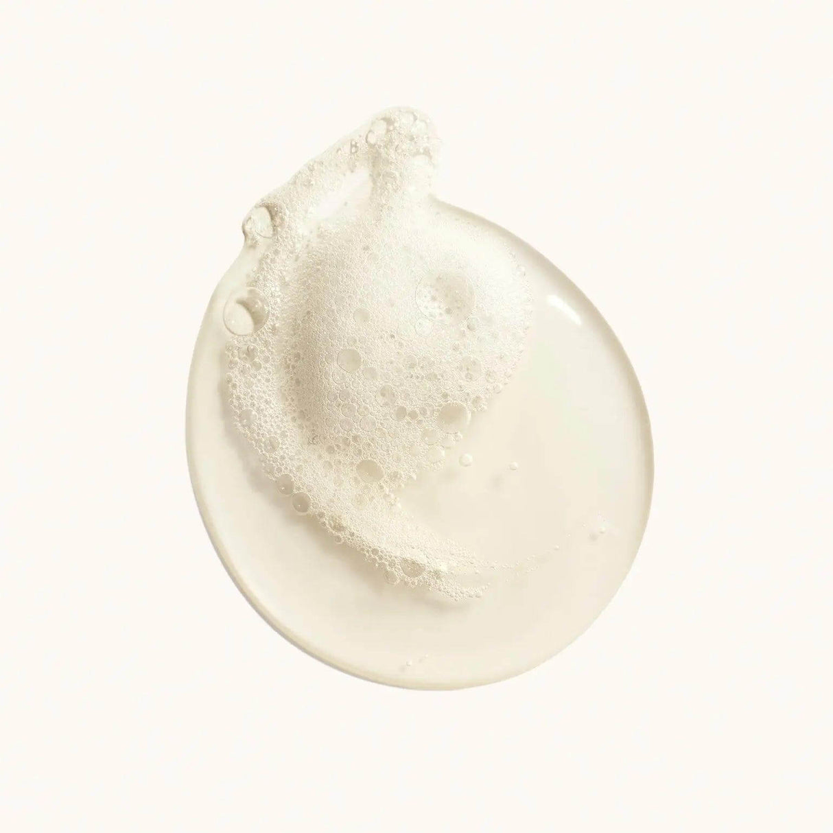 Close-up of Oribe Valley of Flowers Replenishing Body Wash with luxurious lather in a pearlescent formula.