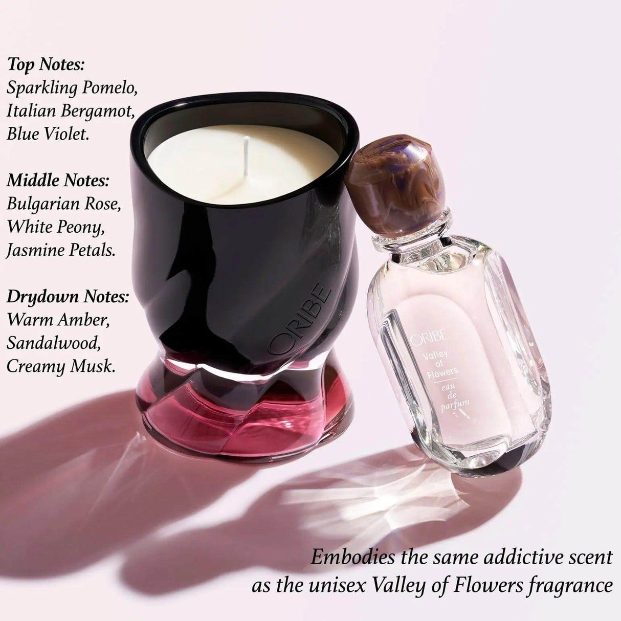 Valley of Flowers Scented Candle by Oribe with fragrance notes, paired with perfume bottle, reflecting floral and musky aroma.