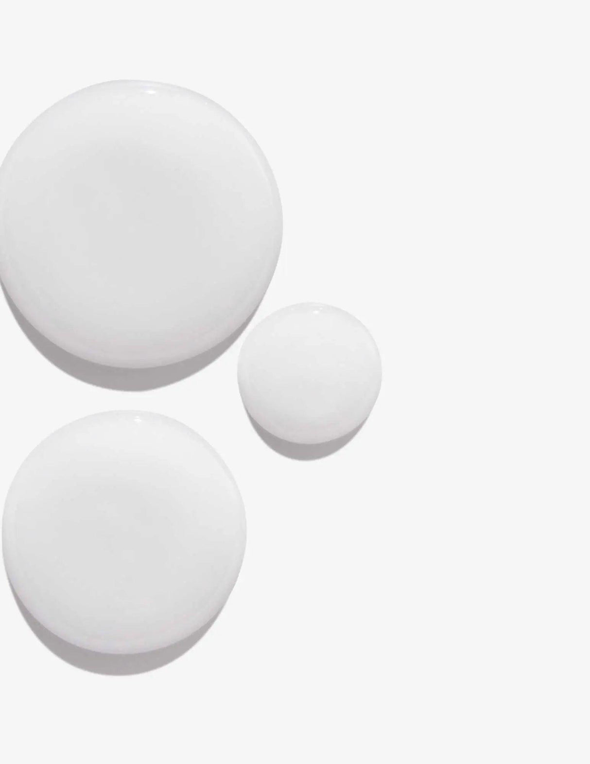 White shampoo droplets on a light background representing Redken Volume Injection Shampoo texture.