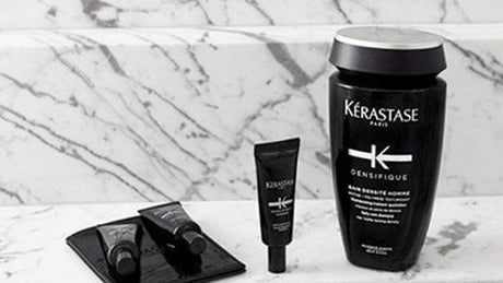 Kérastase hair care products displayed on marble surface.