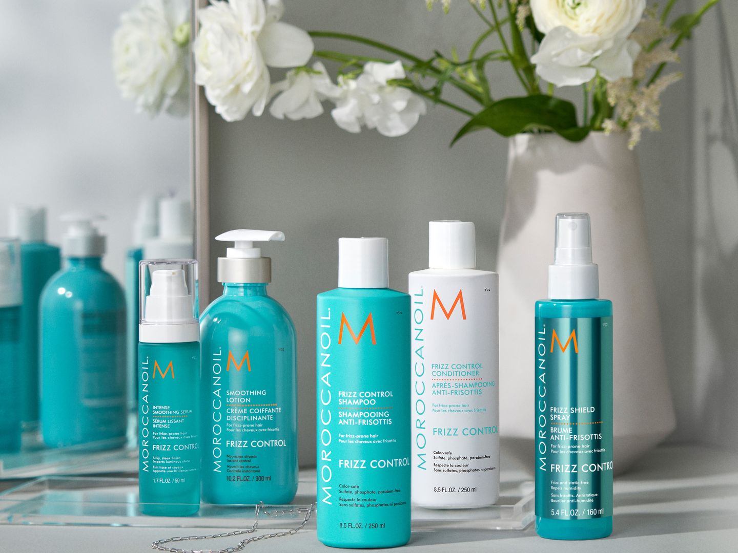 A variety of haircare products displayed on a reflective surface.