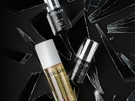Cosmetic products displayed among artistic shattered glass aesthetic.