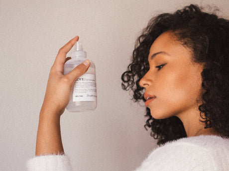 Person holding a translucent bottle of liquid skincare product.