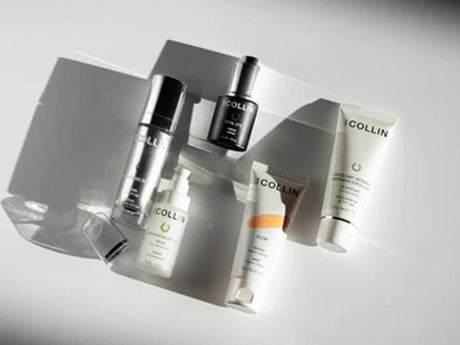 Various skincare products arranged neatly on a reflective surface. 