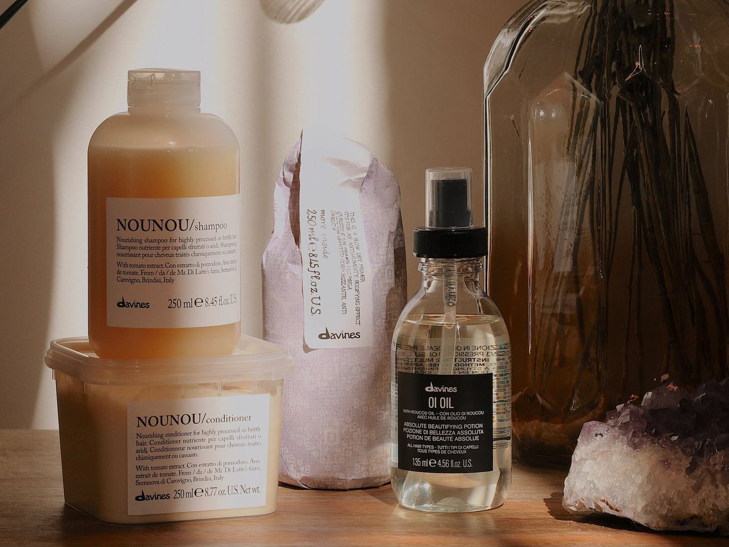 Haircare products displayed with natural lighting and a crystal decoration.