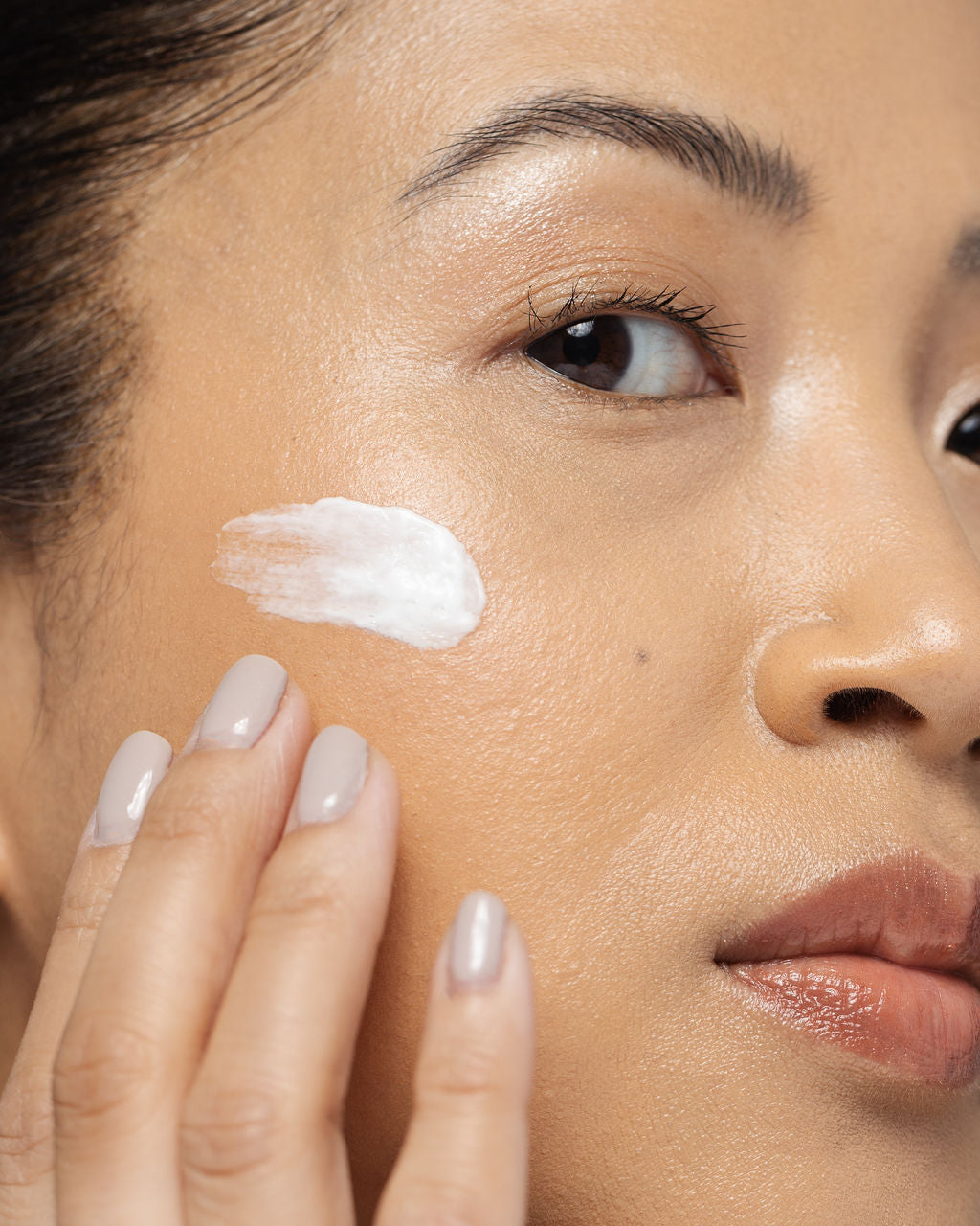 Close-up of a person applying Vivier Nightly Age-Defying Moisturizer to smooth and hydrate skin, minimizing signs of aging.