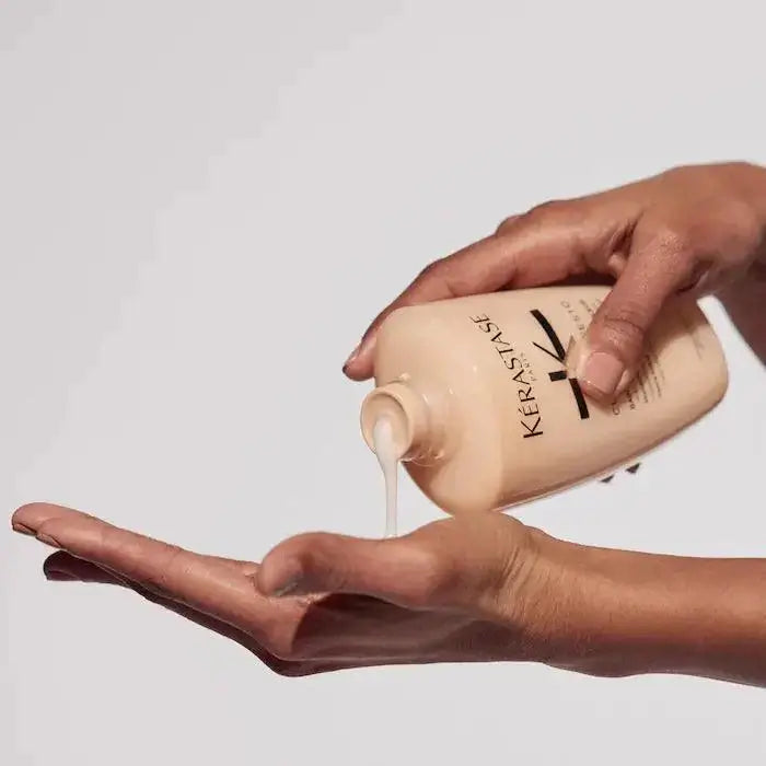 Person dispensing Curl Manifesto Bain Hydration Douceur shampoo, perfect for curly and coily hair, into their hand.