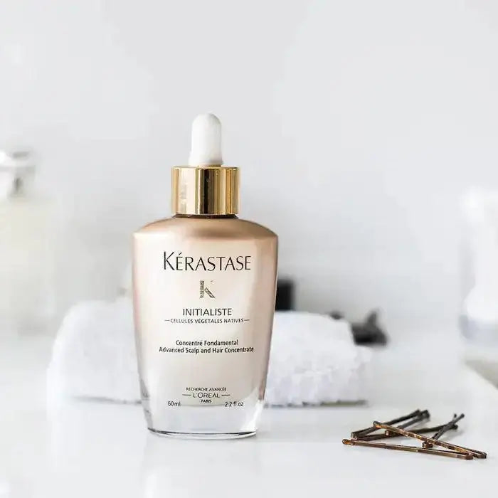 Kérastase Initialiste Strengthening & Volumizing Serum on bathroom counter, purifying and balancing scalp for healthier hair growth.
