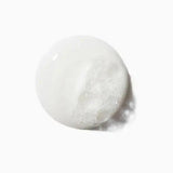 Texture of Kerastase Symbiose Bain Crème Apaisant, mild cleansing shampoo for sensitive scalps, on a white background.